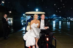 Bride and Groom leave their wedding on a golf cart.